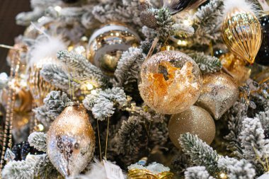 Altın ve gümüş süslemelerle süslenmiş Noel ağacı, tüy ayrıntıları, karımsı elementler, kapalı alanda sıcak ışıklandırma