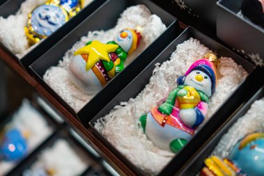 Açık siyah kutularda cam heykelcikler bulunan Noel ve Yeni Yıl dekorasyonunun tepeden tırnağa görüntüsü