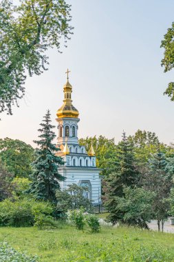 Birden fazla kubbe ve haçı olan küçük bir Ortodoks kilisesi, Kiev 'deki yemyeşil yemyeşil alanlar arasında yer alır.