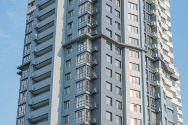 Modern, gösterişli tasarımı olan konut, birden fazla kat, cam panellerle çevrili balkonlar, ön cephe boyunca ritmik desen, gri ve beyaz palet, kentsel ortam, doğal gün ışığı, v yok