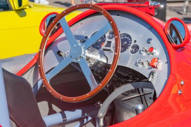 Klasik kırmızı Formula 1 yarış arabası açık kaput, görünür kokpit, göstergeli gösterge paneli, sığ alan derinliği, doğal aydınlatma, muhtemelen bulutlu gün