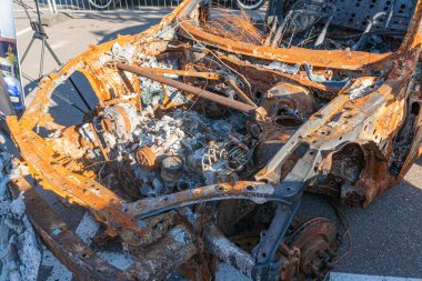 İki ağır hasarlı, karanlık renkli araba dağınık enkaz altında gündüz aydınlatması, kazadan sonraki hasarı kaydeden gizli bir şekilde.