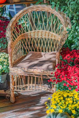 Ahşap güvertede canlı çiçek saksıları, bulutlu bir gün, kırsal hasır tasarımı, yemyeşil bir bahçe.
