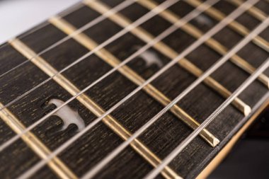 Modern bir heavy rock elektro gitarın yakın çekimi, eskimiş fretboard ve tellere odaklı.