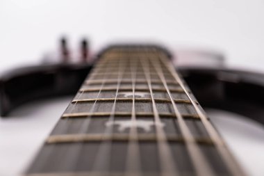 Beyaz arka planda, elektro gitar ensesinin yakın plan görüntüsü yıldız oymalı, hatta aydınlatma, yumuşak gölgeler...