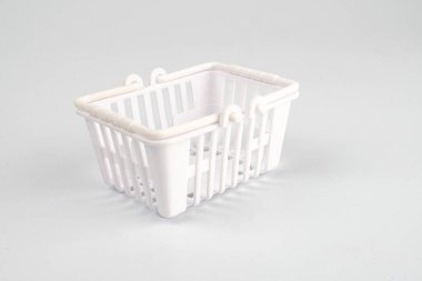 Beyaz arka planda izole edilmiş kırmızı bir çizgi film alışveriş arabası tasarımda birden fazla deliği ve sapı olan nötr bir ışık-c 'ye göre ayarlanmış bir çamaşır sepeti var.