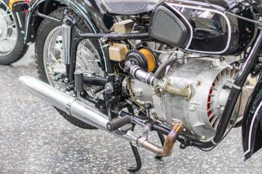 Eski bir motosiklet motorunun yakın plan görüntüsü, karmaşık tasarım ve mekanik hassasiyet sunuyor. Ana bileşenler metalik gümüş, altın, dokular pürüzsüzden tırtıklı.