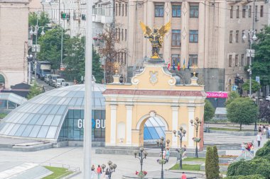 Ukrayna 'nın başkenti Kyiv' de eğri büğrü cepheli ve küçük kubbeli şehir manzarası sütunları, kemerleri ve Kyiv, Ukrayna 07-13-2025 sütunlarıyla süslü tarihi bir anıtın yanında duruyor.