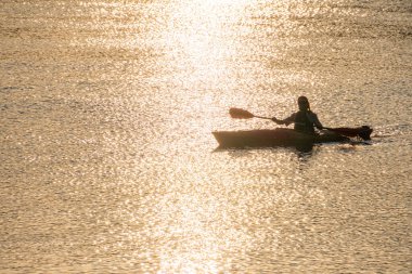 Kyiv, Ukrayna 06-05-2025, sakin, günbatımı ışığında kürek çeken bir insan.