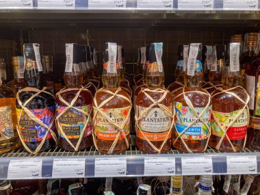 Çeşitli boyutlarda ve tasarımlarda çeşitli içki şişeleri bulunan parlak ışıklı içki dükkanı vitrinleri, bazıları sicimle bağlanmış düzenleme Ukrayna, Kyiv 'deki metal raflarda, 07-03-2025