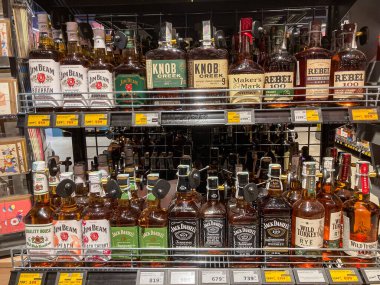 İyi organize edilmiş içki dükkanı rafı, öncelikli olarak viski şişelerine odaklanmış Seçkin Jack Daniels diğer viski markalarının çeşitliliğini gösteriyor Parlak ışıklandırma enh Kyiv, Ukrayna 07-12-2025