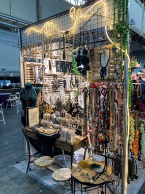 El yapımı mücevherler ve aksesuarların sergilendiği bir fuar tezgahı. Karmaşık boncuklu kolyeler, büyük kolyeler ve bileziklerle birlikte Ukrayna 07-31-2025