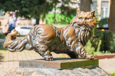 Bronz aslan heykeli kaidede, açık havada ağaçlar ve arkaplan dinamik pozunda bir bina ayrıntılı kaslı bir Kyiv, Ukrayna 07-05-2025