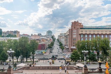 Güneşli bir günde Kyiv şehir meydanında, kırmızı çatıları ve saat kulesi olan süslü binalar, etkinlik, insanlar, ağaçlar, kaldırım taşı yollar, dükkanlar, çeşitli Kyiv, Ukrayna 07-13-2025