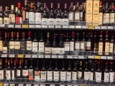 Parlak ışıklandırılmış, iyi stoklanmış bir şarap dükkanı vitrininde, canlı şişeler sergileniyor Kyiv, Ukrayna 07-02-2025