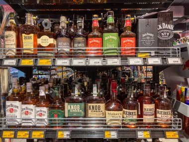 Çeşitli viski şişeleriyle dolu iyi ışıklandırılmış içki dükkanı vitrinleri, ticari bir tarzda titizlikle dizilmiş aydınlatma yumuşak ve doğaldır, B Kyiv, Ukrayna 07-12-2025 'i aydınlatır.