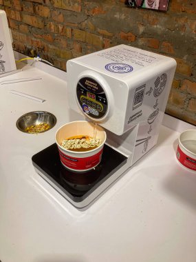 Kore ramen dükkanının kapalı mutfak alanında, beyaz bir tezgah, iki erişte kasesi, bir fincan, başka bir kase, ambalaj malzemeleri ve çeşnili Kyiv, Ukrayna 07-13-2025