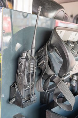 İçerideki itfaiye aracına yakın çekim, güvenli bir telsiz sistemi ve tepedeki kaynaklardan gelen hafif bir başlık.