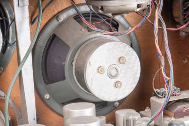 Eski bir tüpün yakın görüntüsü radyo mekanik bileşenler, sergilenen kablolar, makaralar, ve gri ve kahverengi tonlarda metalik bir kapak