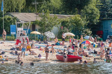 Kyiv, Ukrayna 'da yüzen, güneşlenen ve kumsalda oynayan kumsalda şemsiyeler, göl ya da deniz, yakınlarındaki yüzgeçli evler Trees a Kyiv, Ukrayna 07-12-2025