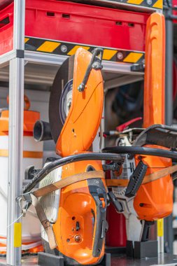 Endüstriyel çalışma alanı veya depo Turuncu ve siyah motorlu testere ünitesi seyyar stantta, çoklu bıçaklı, merkezi kırmızı çizgili, gölgeli aydınlatma diğer mekanik arka planda