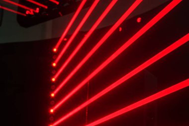 Dinamik kırmızı ve mavi ışıklandırmalı lazer gösterisi, yukarıdan birden fazla çizgili dikey çizgilere odaklanıyor, soyut moda ile dayanıklı bir yapıyı aydınlatıyor