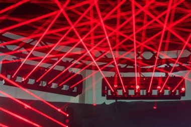 Konser sahnesindeki canlı kırmızı davul setinin yakın plan görüntüsü kırmızı ve mor ışıkla yıkanmış sığ alan derinliği performanstan önce beklenti yaratır.