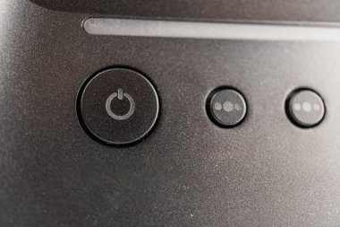 Açıklamanın özeti, modern bir mini gitar yükseltici hoparlörünün, biri diğerlerinden daha büyük, üç düğmeli kontrol paneli olan, yakın plan görüntüsü.