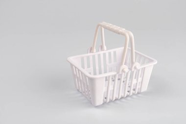 Beyaz arka planda kırmızı çizgi film mini alışveriş arabasının özet resmi. Altında boş beyaz bir çamaşır sepeti var. Aydınlatma bile.