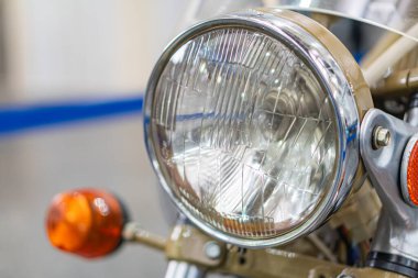 Antika motosiklet, motor ve farlı büyük metalik makine, turuncu güvenlik ışıkları, endüstriyel fon, bulanık alan derinliği, yapay ışık