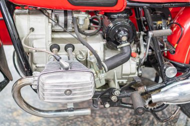 Kırmızı antika bir motorun yakın çekim görüntüsü, gümüş metal bileşenler, şanzıman veya şanzıman, arka teker, siyah lastik ve plastik parçalar, klasik tasarım, yuvarlak şekiller,