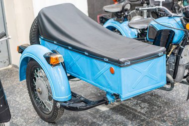 Sidecar 'lı klasik mavi motosiklet, kapalı bir yerde, siyah bir brandanın altında, klasik tasarım, 20. yüzyılın ortalarındaki modelleri anımsatıyor, yuvarlak far, krom parçalar, üniforma döşemesi, insan ya da si yok.