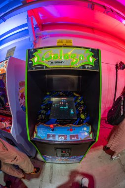Gecelik atari sahnesinde çoklu oyuncu kontrolörlü renkli bir Galaga slot makinesi vardı, sıcak neon ışıklarına daldırılmıştı, diğer insanlar da vardı, Kyiv, Ukrayna 'ya katkıda bulunuyorlardı - 7 Haziran 2025