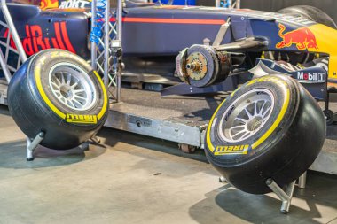 A vibrant blue, yellow, and red Formula 1 car rests on a gray platform within an industrial space The car is sleek, with aerodynamic design, tires off the ground, a Kyiv, Ukraine - June 7, 2025
