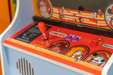 Yarış grafikleri ve direksiyon simidi olan turuncu oyun dolabı kontrol alanı etrafında birden fazla düğme ve küçük bir hoparlör Kyiv, Ukrayna - 7 Haziran 2025