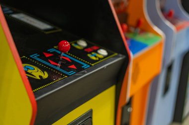 Bir joystick ve üst kısımdaki Retro grafikler için iki kırmızı düğme içeren sarı bir oyun makinesinin yakın plan görüntüsü Kyiv, Ukrayna - 7 Haziran 2025