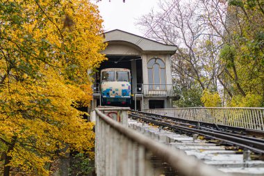 Sonbaharda parktaki beton köprüde mavi-beyaz tren vagonu, Kyiv, Ukrayna aileleri için eğlence gezisinin bir parçası - 24 Ekim 2025