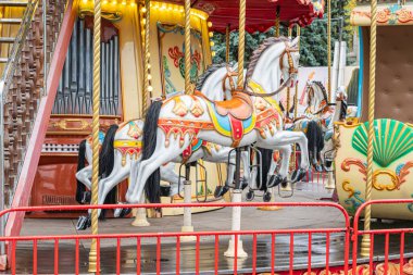 Ahşap platformdaki renkli atlıkarınca kırmızı korkulukla süslenmiş, değişik duruş ve renklerle süslenmiş Rustik platform canlı renkler Kyiv, Ukrayna - 25 Ekim 2025