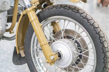 Sarı KMZ Dnipro Antika motosiklet tekerleği, beton bir zeminde asılı, zıt gümüş teller ve siyah lastikler, doğal ışıklandırma, düşük açılı pe Kyiv, Ukrayna - 25 Ekim 2025