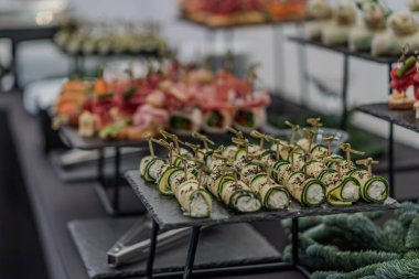 Karanlık bir masada titizlikle hazırlanmış ordövrleri olan kumarhane içi doğal ışık, salatalık kremi peynirli şiş, havuç, sashimi ve maydanozun rengini ve dokusunu vurguluyor.