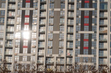 Yansıtıcı pencereli, dinamik gölgeli ve röfleli modern gri apartmanın yakın görüntüsü, değişen pencere boyutları, geometrik desenler, fonksiyonel tasarım ve birden fazla kat perspektifi