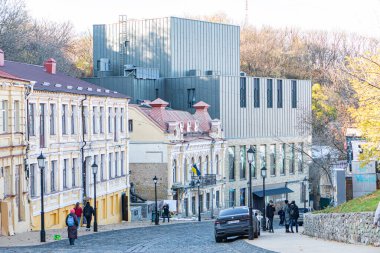 Tarihsel Kyiv sokak sahnesi, kaldırım taşı yol, klasik cepheli çok katlı binalar, süslü sütunlar, balkonlar, renk çeşitliliği bej, kahverengi, u Kyiv, Ukrayna - 3 Kasım 2025