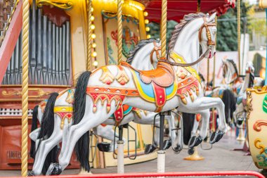 Atlıkarınca sahnesi, canlı kırmızı ve sarı atlıkarınca, çeşitli renklerde çeşitli at tasarımları, yan görüş, karmaşık atlı karınca detayları, Kyiv, Ukrayna - 25 Ekim 2025