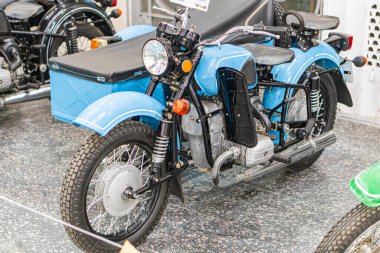 Beton zemine park etmiş mavi ve siyah bir KMZ Dnipro antika motosikletli kapalı bir sahne. Büyük motor ve egzoz borusuyla işaret edilen sağlam tasarım. Kyiv, Ukrayna - 25 Ekim 2025