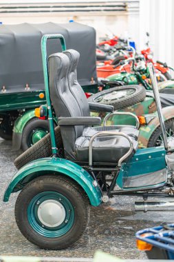 Klasik yeşil motorlu üç tekerlekli bisiklet, KMZ Dnipro Antique model, kapalı alanda park edilmiş iki koltuk, büyük yuvarlak far, Kyiv, Ukrayna - 25 Ekim 2025