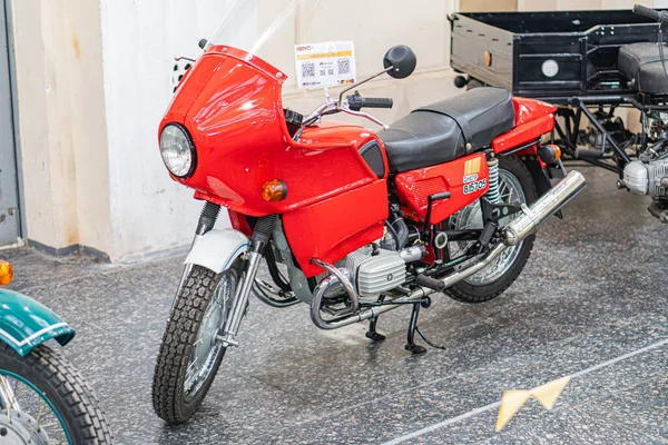 Klasik kırmızı KMZ Dnipro ve kapalı sergi ortamında klasik motosikletler, doğal ışıklandırma gölgeleri döşeme yeri ve nötr arka plan Kyiv, Ukrayna - 25 Ekim 2025