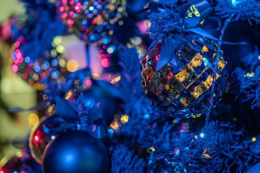 Kumarhanenin içindeki parlak, küresel tatil dekorasyonunun yakın plan görüntüsü, yansıtıcı yüzeylere ve yapraklı detaylara sahip kırmızı, yeşil ve altın kürelerin egemenliği altında.