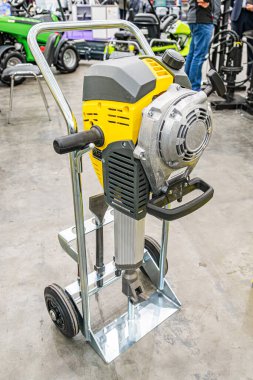 Mobil metal bir standın üzerinde sarı beton bir testere, koruyucu konut sanayi ortamında büyük bir motor ve dönen bir bıçak, traktörler gibi tarım ekipmanları yakındaki yapay ışıklandırma sha