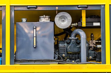 Bir atölye veya fabrika içindeki endüstriyel makinelerin yakın görüntüsü Tanklar, borular, dişliler, potansiyel kablolama silindirli tanklar dahil olmak üzere sarı ve gri makineler