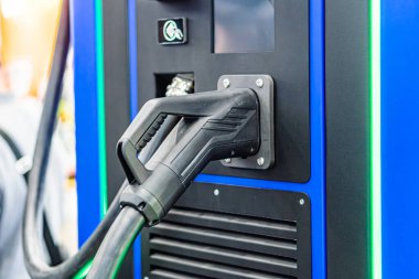 Metal bileşenli mavi şarj istasyonu, dikdörtgen şekilli, çoklu yan bağlantılar, siyah kablo, kapalı alanda ışıklandırma